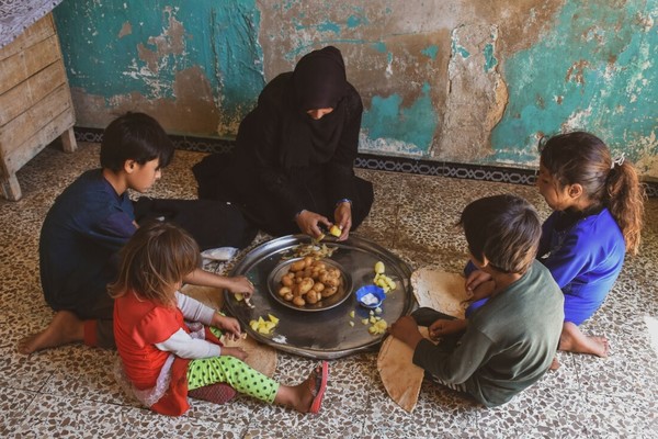 시리아 알레포주에 사는 한 여성이 자녀들에게 한끼 식사로 먹을 감자를 나눠주고 있다. 10년간 이어진 내전과 코로나19로 인한 경제적 충격으로 시리아 국민 5명 중 3명이 심각한 기근을 겪고 있다./사진=옥스팜