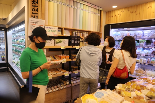 한살림 가락매장 이지현 팀장(오른쪽에서 세번째)이 매장을 찾은 조합원에게 제품 시식을 권하며 '상생마켓' 제품을 적극적으로 소개하고 있다.