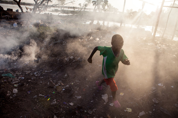 아프리카 말리 수도 바마코(Bamako)의 니제르 강 근처에서 한 어린이가 쓰레기 태우는 연기를 피해 뛰어가고 있다./ 출처=유니세프한국위원회