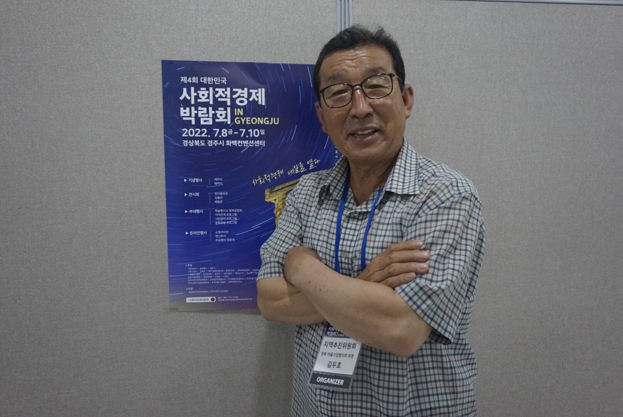 박람회 포스터 앞에서 포즈를 취한 김두호 대표 / 사진=박초롱 기자