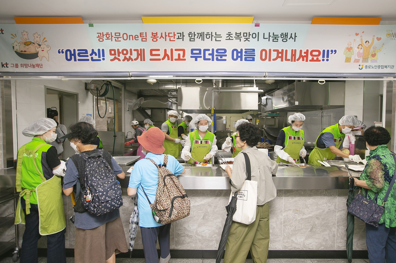 광화문ONE팀 봉사단이 종로노인복지관을 이용하는 어르신들에게 전복 삼계탕을 배식하고 있다. 사진제공=KT