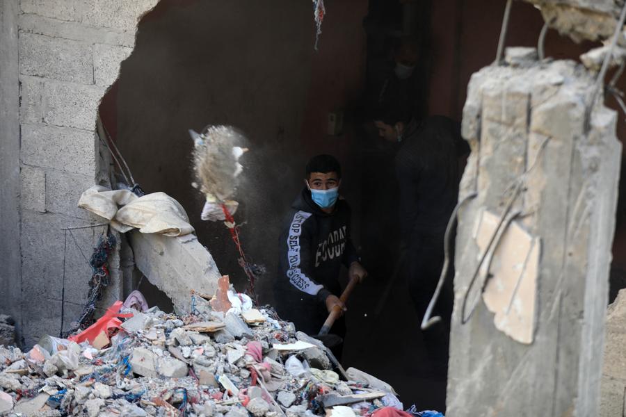 24일 가자지구 남부 도시 라파에서 사람들이 군사 공격으로 파괴된 건물 잔해를 정리하고 있다. (사진/신화통신)