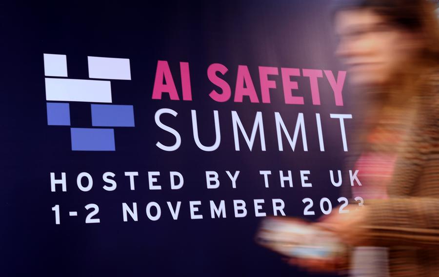 한 참가자가 지난 11월 2일 영국 블레츨리 파크에서 '제1회 인공지능(AI) 안전성 정상회의' 홍보 판넬 앞을 지나가고 있다. (사진/신화통신)