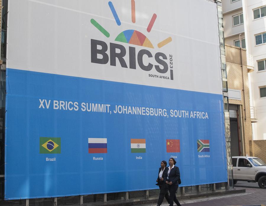 행인들이 8월 21일 남아프리카공화국 요하네스버그에서 '제15차 브릭스(BRICS) 정상회의'가 열리는 샌톤 컨벤션센터를 지나고 있다. (사진/신화통신)