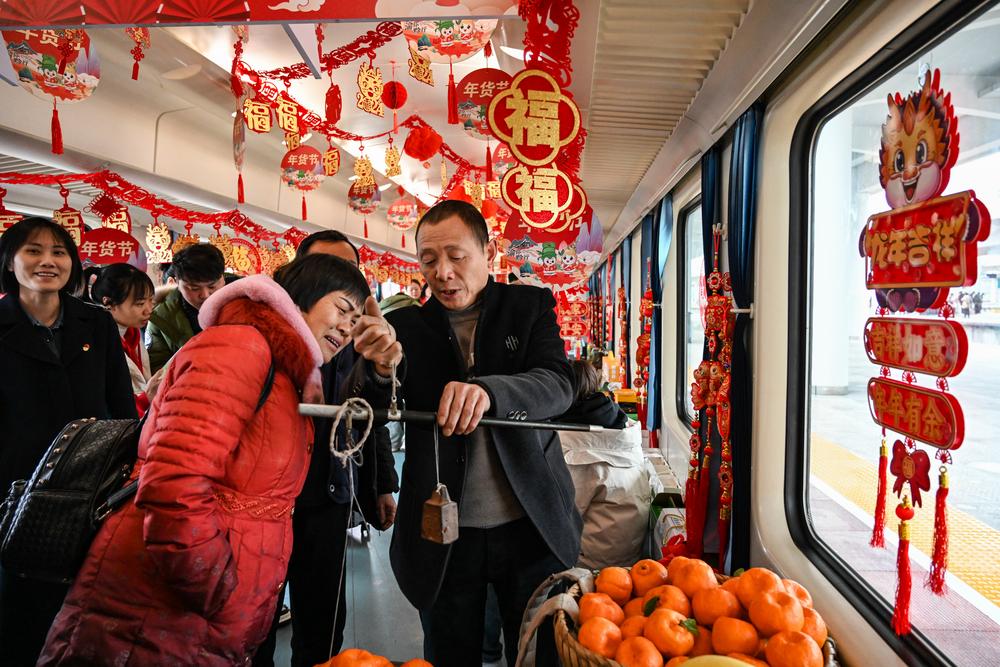 (중국 충칭=신화통신) 한 여객이 5일 구이저우(貴州)성 쭌이(遵義)역에서 충칭(重慶)서역으로 가는 5630편 열차에서 마을 사람들이 판매하는 농산물을 구매하고 있다. 최근 중국철로 청두(成都)국그룹은 쭌이역에서 충칭서역을 오가는 5630, 5629편 열차에서 춘절 맞이 용품 장터를 열었다.
