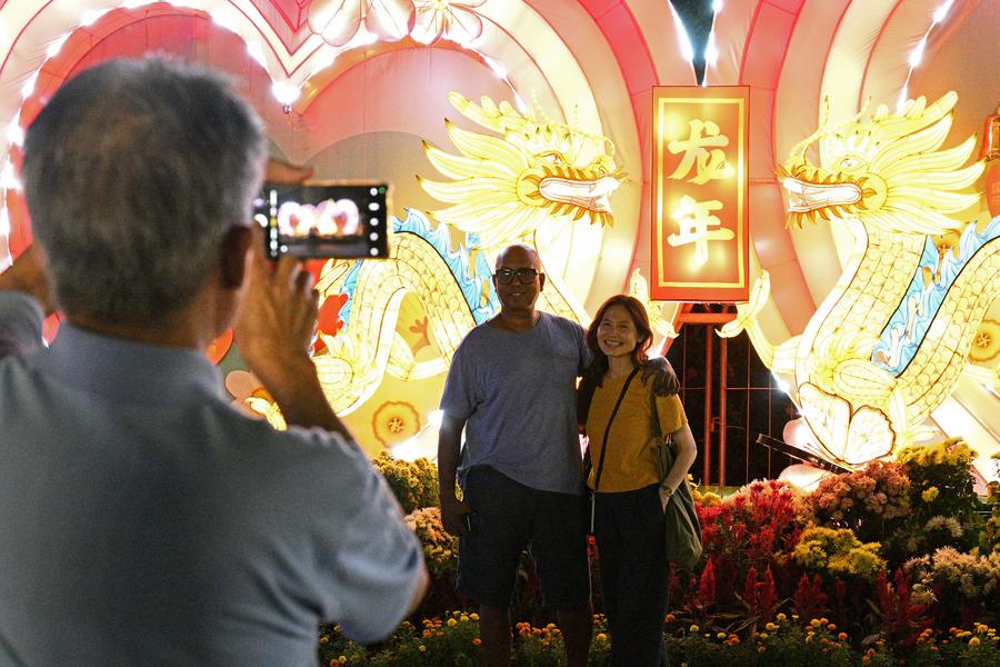 싱가포르 가든스 바이 더 베이를 찾은 관광객들이 8일 '용의 해' 꽃등을 배경으로 기념사진을 찍고 있다. (사진/신화통신)
