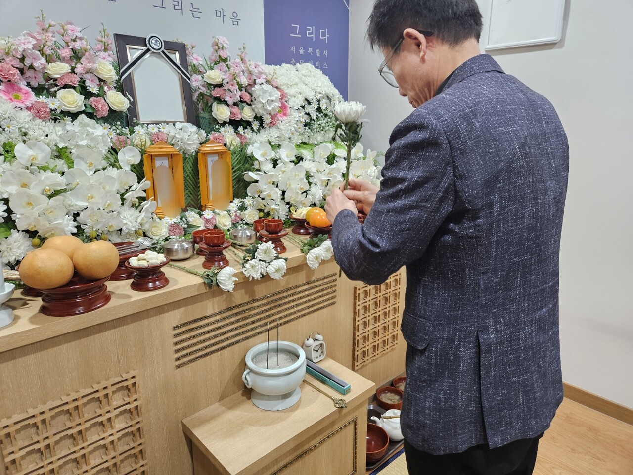 지난 17일 경기 고양시 서울시립승화원에서는 무연고 사망자를 위한 공영 장례가 치러졌다. 사진은 헌화를 하는 한 장례지도사.