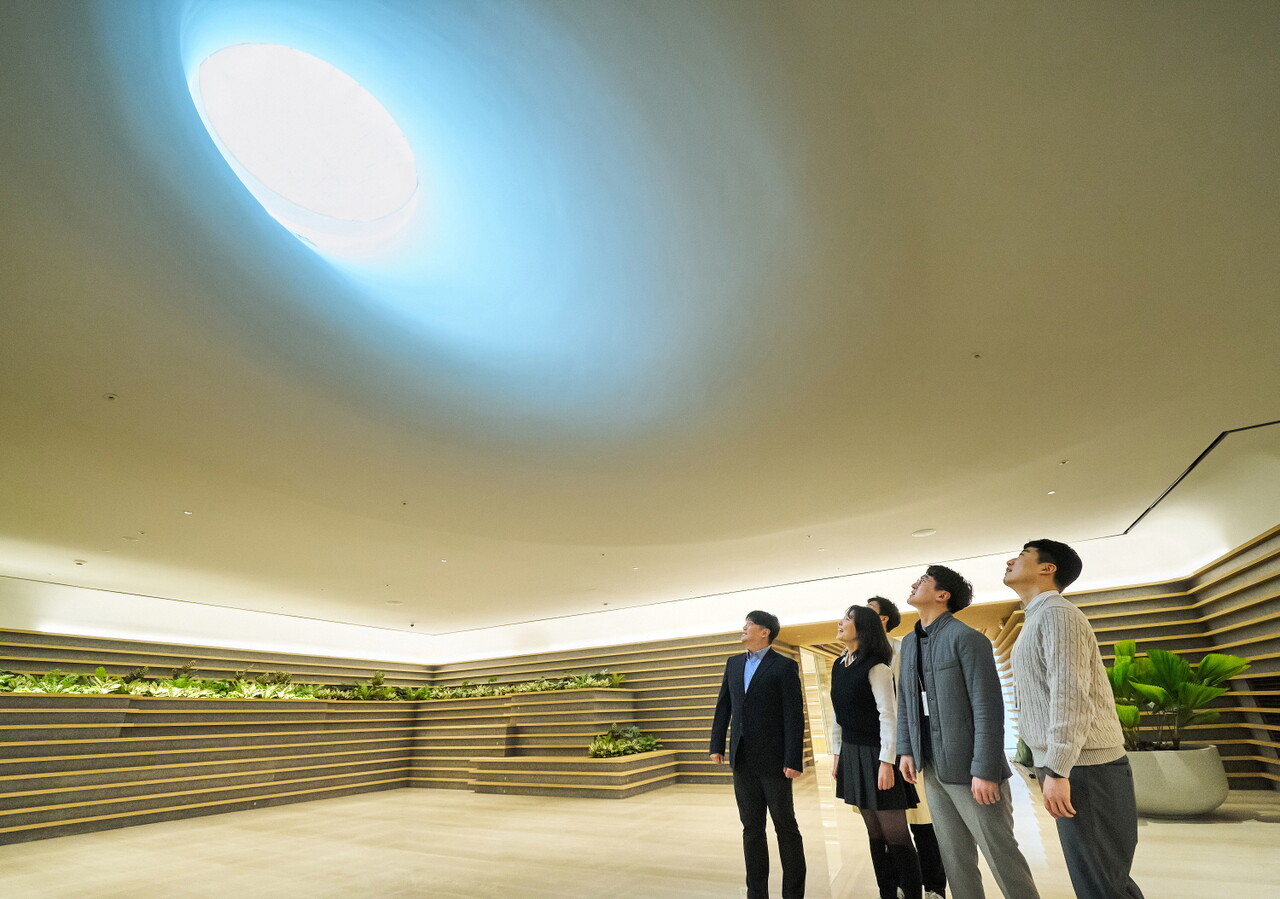 직원들이 LG트윈타워 지하 1층에 새로 조성된 '틴들'에서 햇빛이 들어오는 천장을 바라보고 있다. / 사진=LG