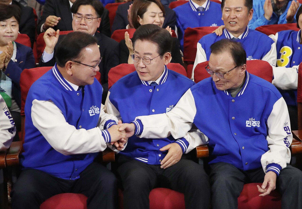 이재명 더불어민주당 대표, 이해찬·김부겸 상임공동선거대책위원장이 10일 오후 서울 여의도 국회 의원회관에 마련된 제22대 국회의원선거(총선) 민주당 개표 상황실에서 방송사 출구조사 결과를 지켜본 훈 악수를 나누고 있다. (공동취재) 2024.04.10.