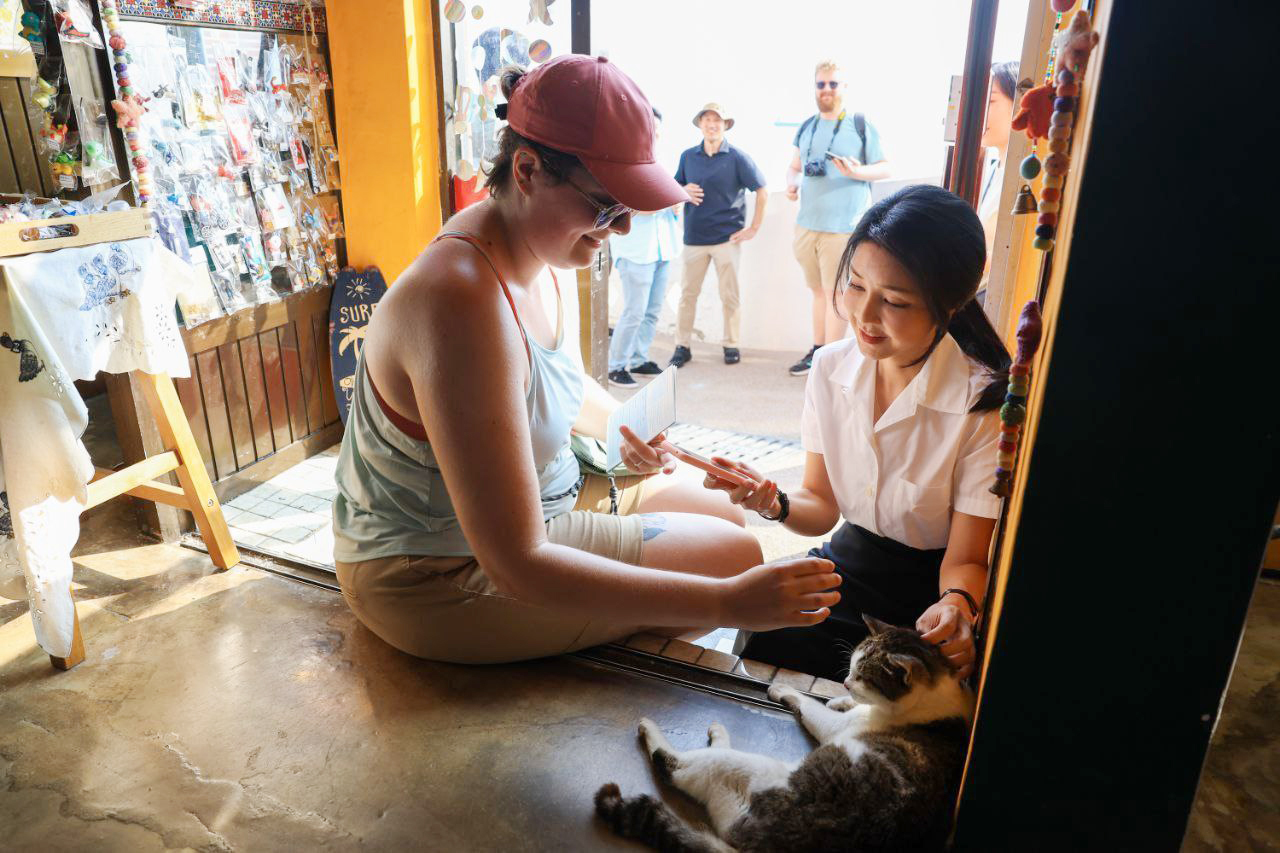 여름 휴가중인 윤석열 대통령 부인 김건희 여사가 7일 부산 영도 흰여울 문화마을을 찾아 외국인과 고양이를 보며 대화하고 있다. (사진=대통령실 제공) 2024.08.08. /뉴시스