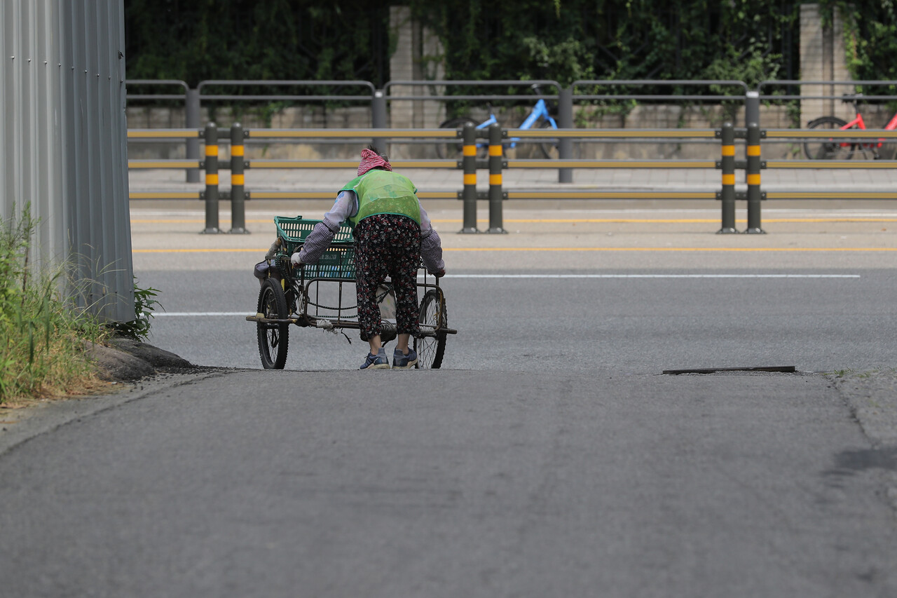 전국 대부분 지역에 폭염 경보가 내려진 31일 서울 서초구 서초대로 인근에서 한 할머니가 수거한 폐지를 고물상에 내다판 뒤 돌아가고 있다. 이날 할머니는 폭염 속에 폐지 수거를 마친 뒤, 고물상에서 건넨 4000원을 받아 들고 "우리 같은 사람들은 비 오는 거보다 해 찌는 게 나아, 박스 다 젖어"라며 웃어 보였다. 2023.07.31./사진=뉴시스