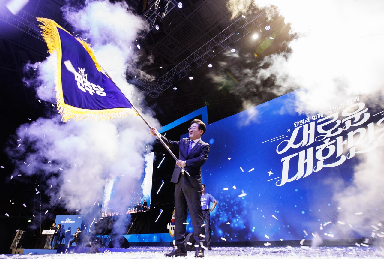 이재명 더불어민주당 신임 대표가 18일 오후 서울 송파구 올림픽공원 KSPO돔에서 열린 더불어민주당 제1차 정기전국당원대회에서 당기를 흔들고 있다. (공동취재) 2024.08.18.