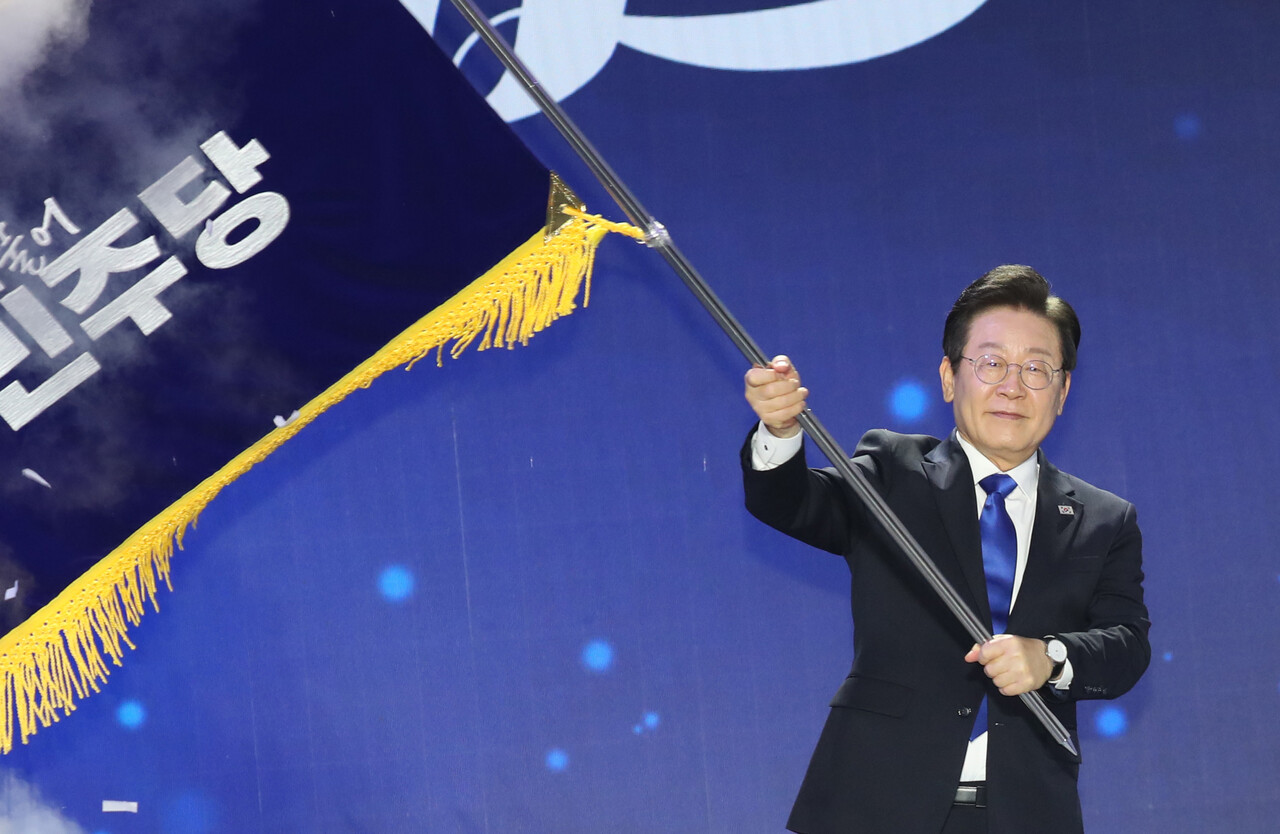 연임에 성공한 이재명 더불어민주당 신임 대표가 18일 서울 송파구 KSPO DOME(올림픽체조경기장)에서 열린 더불어민주당 제1차 정기전국당원대회에서 대표 선출 후 당기를 이양받아 흔들고 있다./사진=뉴시스