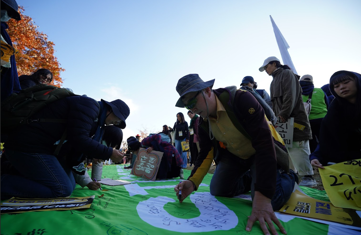 23일, 전 세계 시민 1,000여 명과 16개 환경단체로 구성된 ‘플뿌리연대’가 벡스코를 중심으로 ‘강력한 국제 플라스틱 협약을 위한 1123 시민행진’에 나선 가운데, 행진 도착점에서 시민들이 ‘플라스틱, 이제 그만(No More Plastic)’ 메시지 현수막에 손도장을 찍고 있다. 사진=플뿌리연대