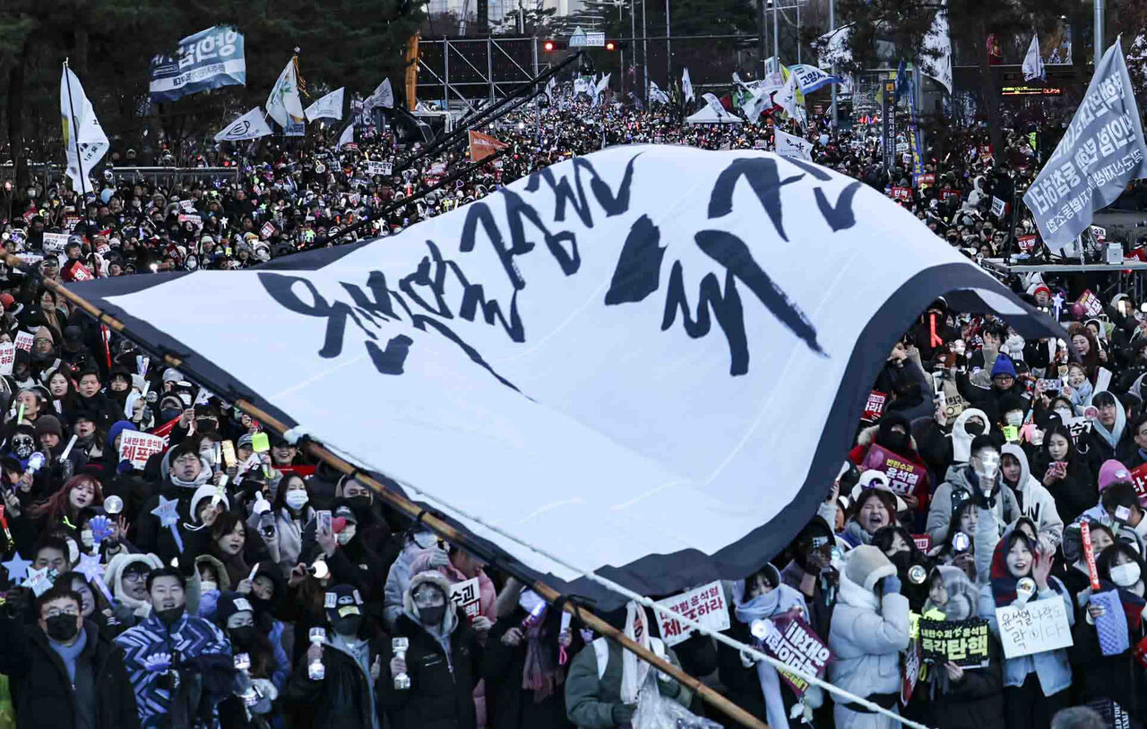 윤석열 대통령에 대한 탄핵 소추안 재표결이 통과된 12월 14일 서울 여의도 국회의사당 앞에서 시민들이 윤석열 대통령 탄핵소추안 국회 통과 촉구 집회에서 기뻐하고 있다. / 사진=뉴시스