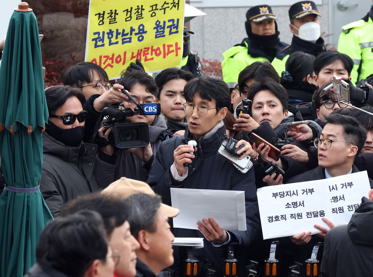차성안 서울시립대 법학전문대학원 교수와 윤석열체포변호사단이 13일 오전 서울 용산구 한남동 대통령 관저 입구에서 경호처 직원들에게 부당 지시 거부 소명서를 배포하겠다며 입장을 밝히고 있다. 2025.01.13./뉴시스