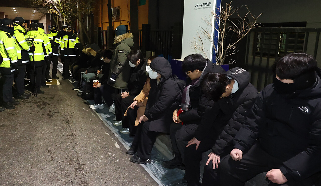 내란 수괴와 직권남용 등의 혐의를 받는 윤석열 대통령의 구속 전 피의자 심문(영장실질심사)이 열린 1월 8일 서울 마포구 서울서부지방법원에서 담을 넘어 경내로 들어온 윤 대통령 지지자들이 경찰에 연행되어 있다.(공동취재) / 사진=뉴시스