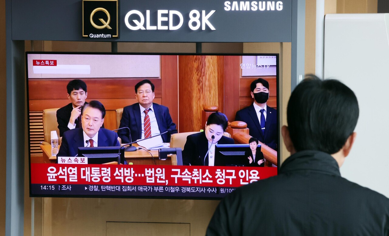 법원이 내란 우두머리(수괴) 혐의로 구속 기소된 윤석열 대통령의 구속 취소 청구를 인용한 7일 오후 서울 중구 서울역 대합실에서 이용객들이 관련 뉴스를 시청하고 있다 / 사진=뉴시스