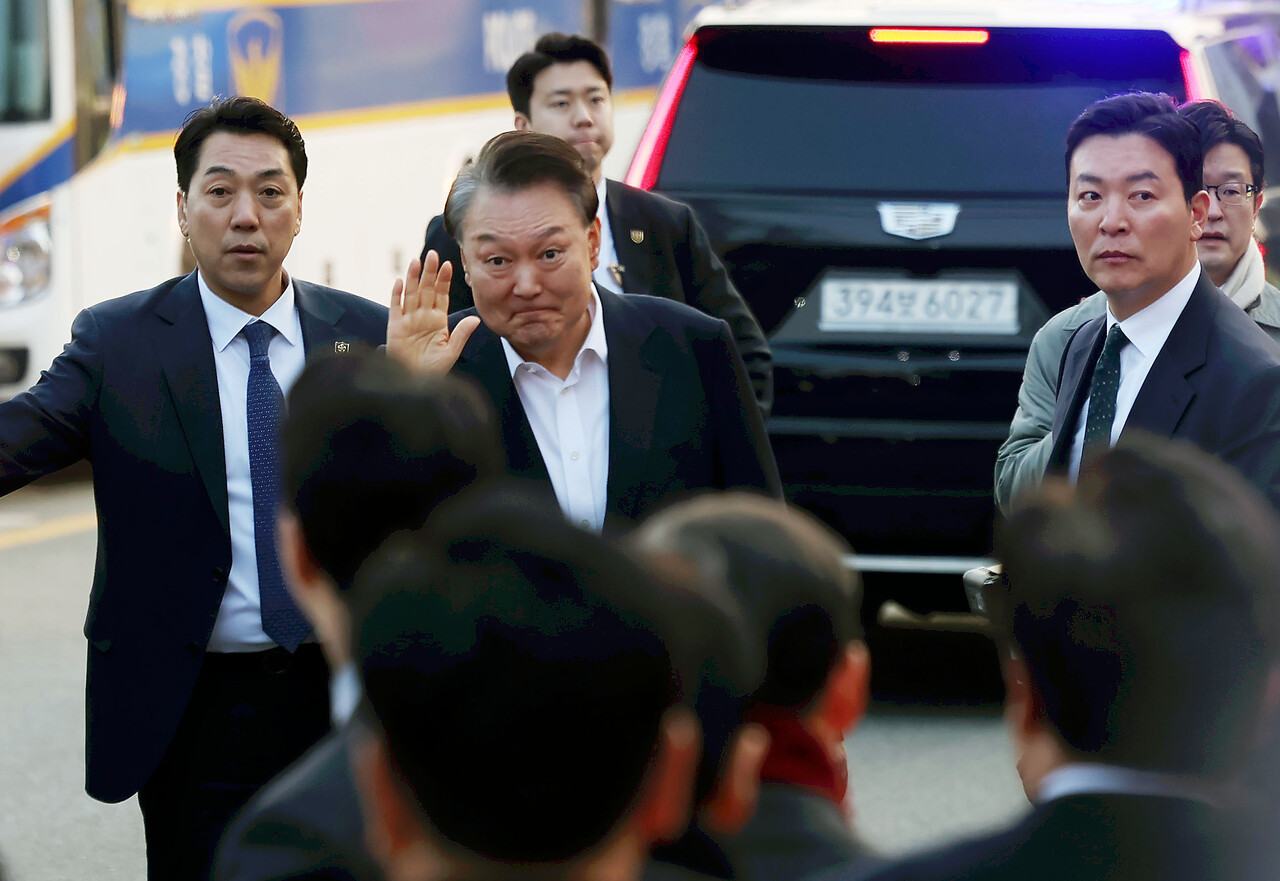 석방된 윤석열 대통령이 8일 오후 경기 의왕시 서울구치소 앞에서 지지자들에게 인사하고 있다. 윤 대통령 오른쪽은 김성훈 경호처 차장. 2025.03.08./뉴시스