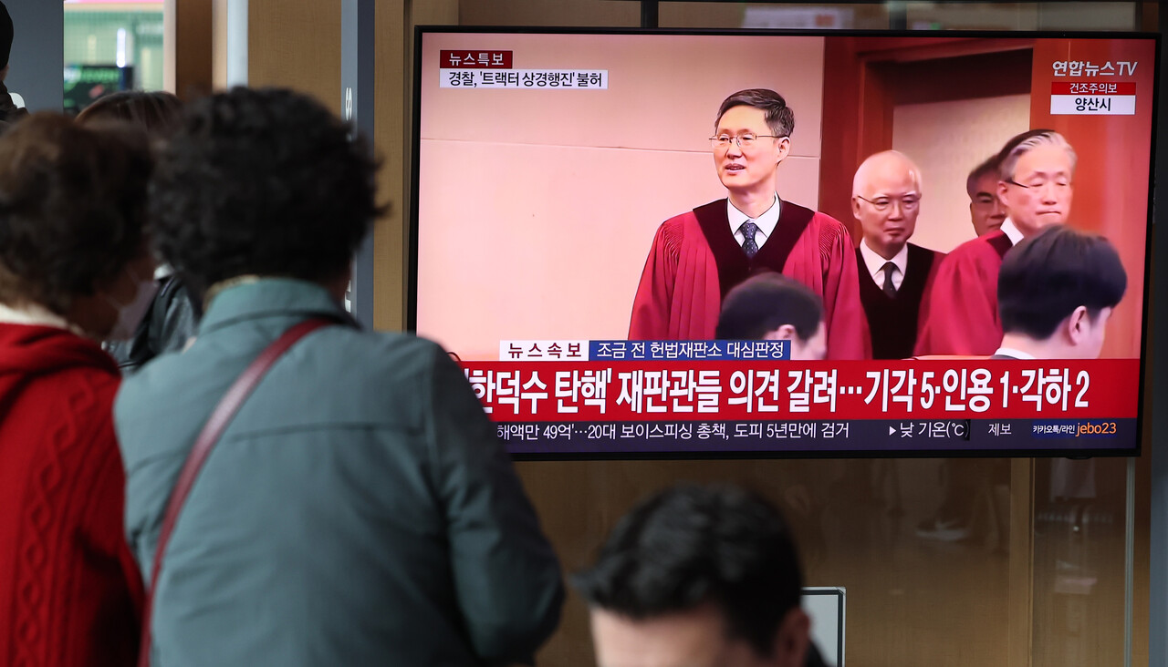 24일 오전 서울 용산구 서울역 대합실에서 시민들이 한덕수 국무총리 탄핵심판 선고 관련 뉴스를 시청하고 있다. 2025.03.24./뉴시스