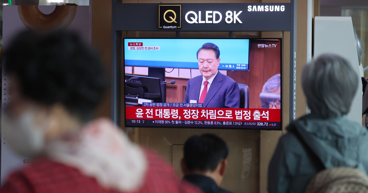 21일 서울역 대합실에서 시민들이 TV를 통해 윤석열 전 대통령에 대한 내란 우두머리 혐의 2차 공판 모습을 시청하고 있다. 2025.04.21./뉴시스