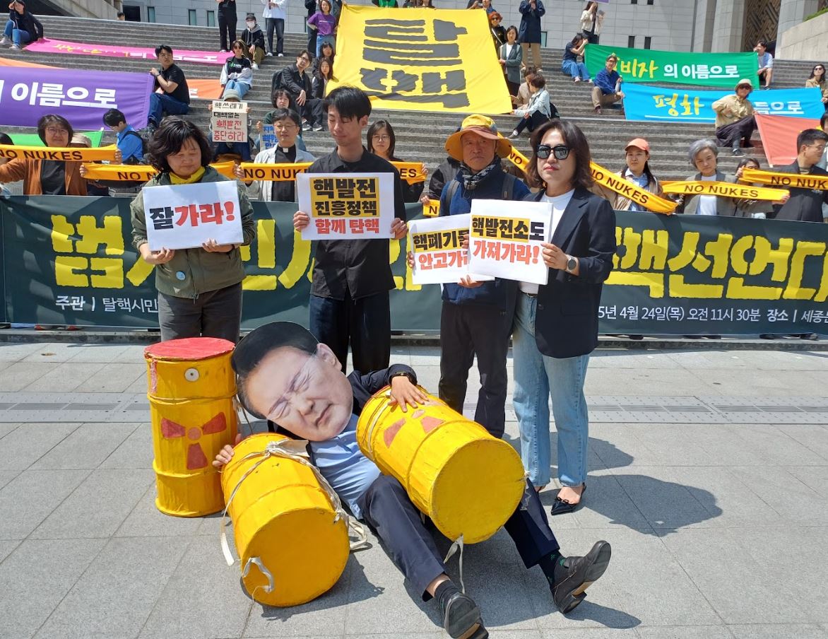 4월 24일 열린 '탈핵선언대회 - 2025 대선, 윤석열의 핵 정책을 파면한다.'에서 핵폐기물을 짊어지고 쓰러진 윤석열 전대통령에게 "핵과 함께 잘 가라"고 인사하는 시민들의 퍼포먼스 ./사진제공= 탈핵시민행동
