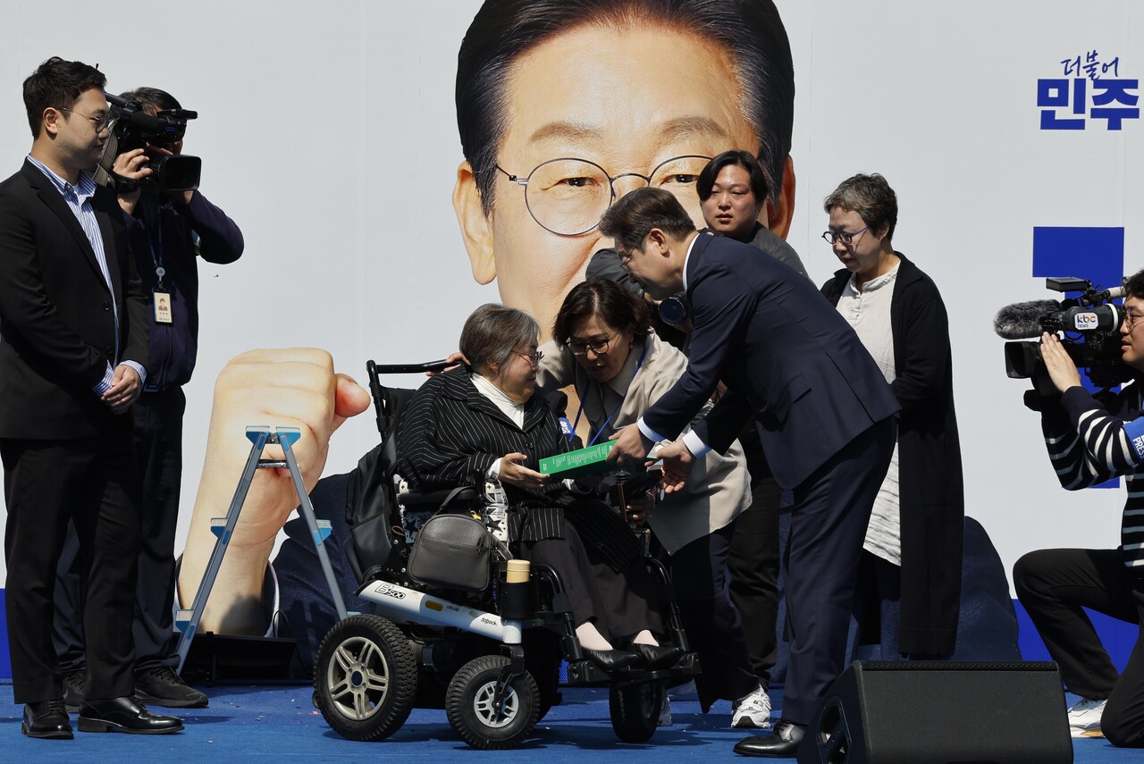 이재명 더불어민주당 대선후보가 제21대 대통령선거 공식 선거운동이 시작된 12일 오전 서울 청계광장에서 열린 중앙선거대책위원회 출정식에서 박김영희 씨에게 모두의 질문Q 녹서를 전달받고 있다. /사진=뉴시스