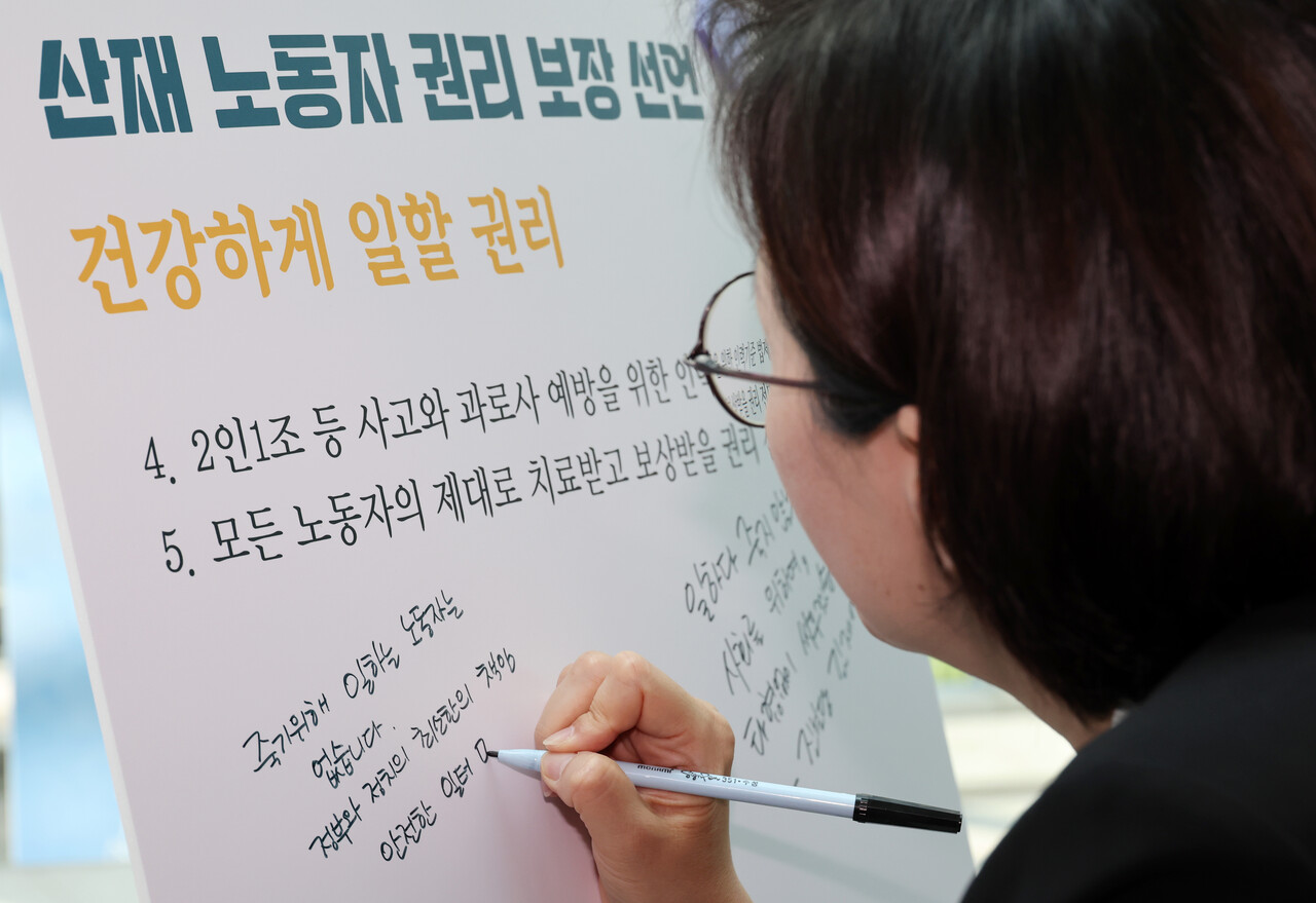 정혜경 진보당 의원이 28일 오후 서울 여의도 국회 의원회관 로비에서 개막한 4.28 산업재해 노동자의 날 국가기념일 지정 첫 해 기념 '싸우는 산재노동자 사진전'에서 추모 메시지를 적고 있다. /사진=뉴시스